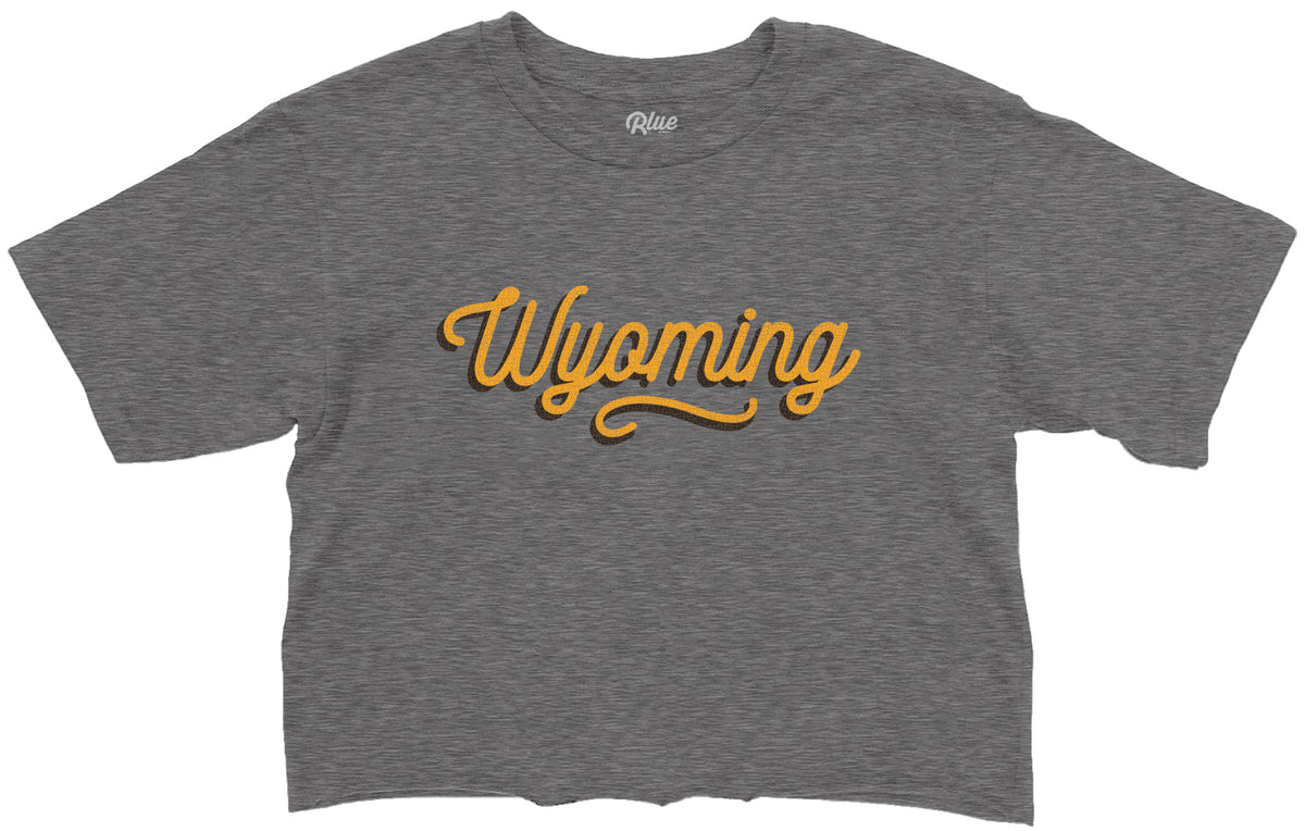 grey womens cropped short sleeve with gold wyoming script with brown shadow centered on the chest.