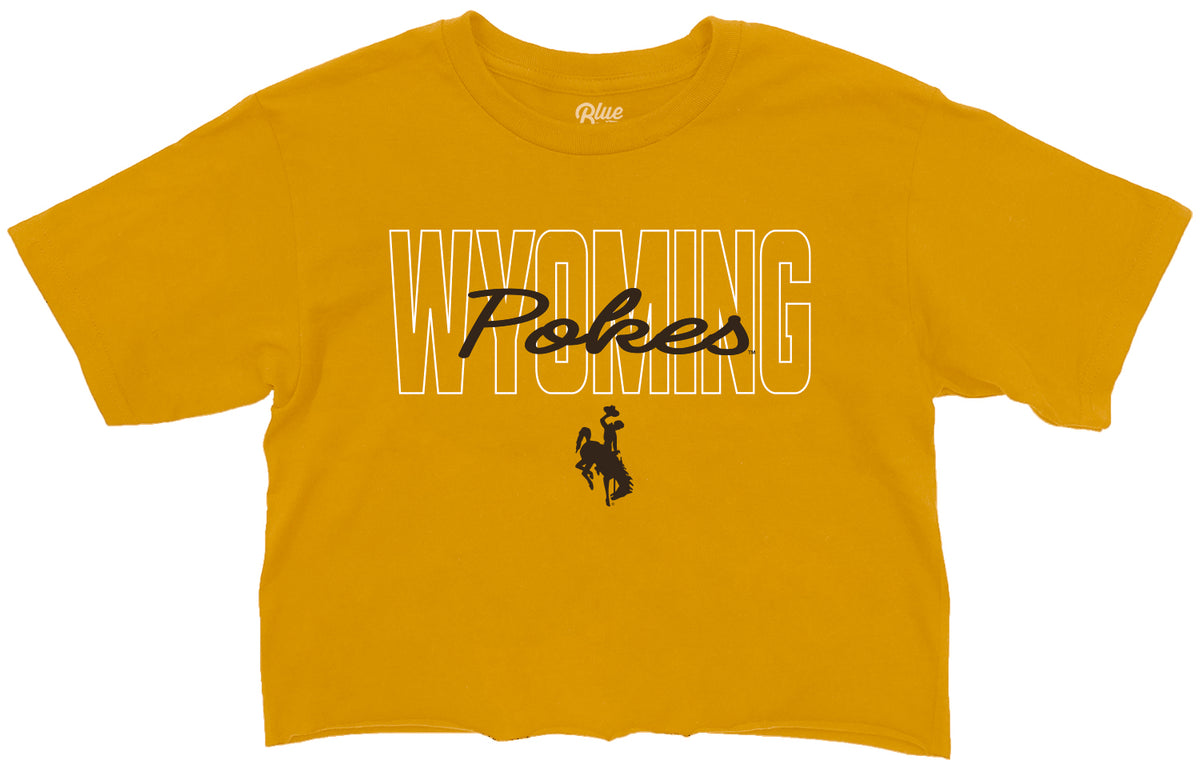 gold womens crop tee with white and brown design centered. design is white outlined wyoming with brown pokes script brought to front and brown bucking horse below
