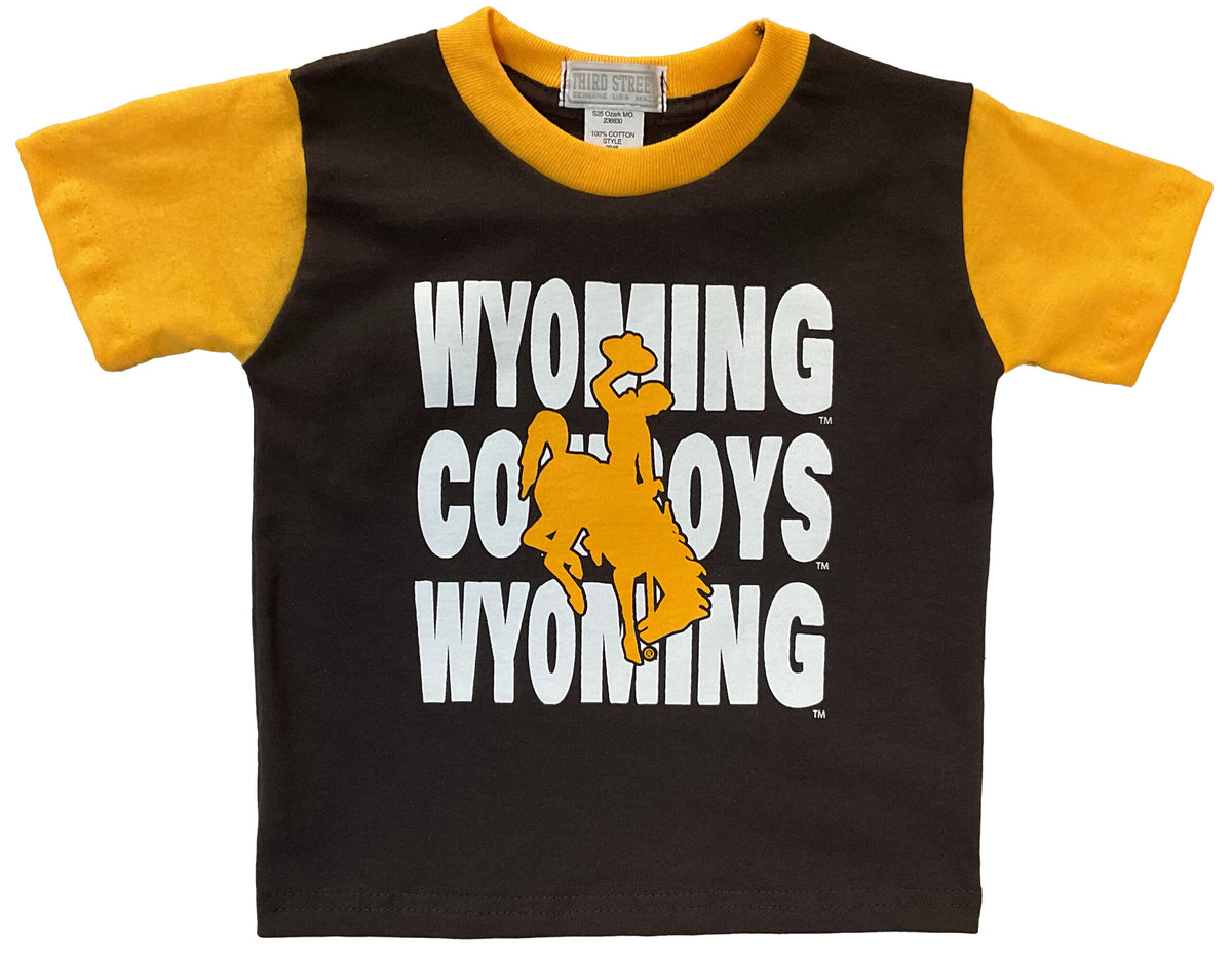 brown toddler and infant tee with gold sleeves/collar, design is white wyoming cowboys wyoming repeat centered with gold bucking horse brought to the front.