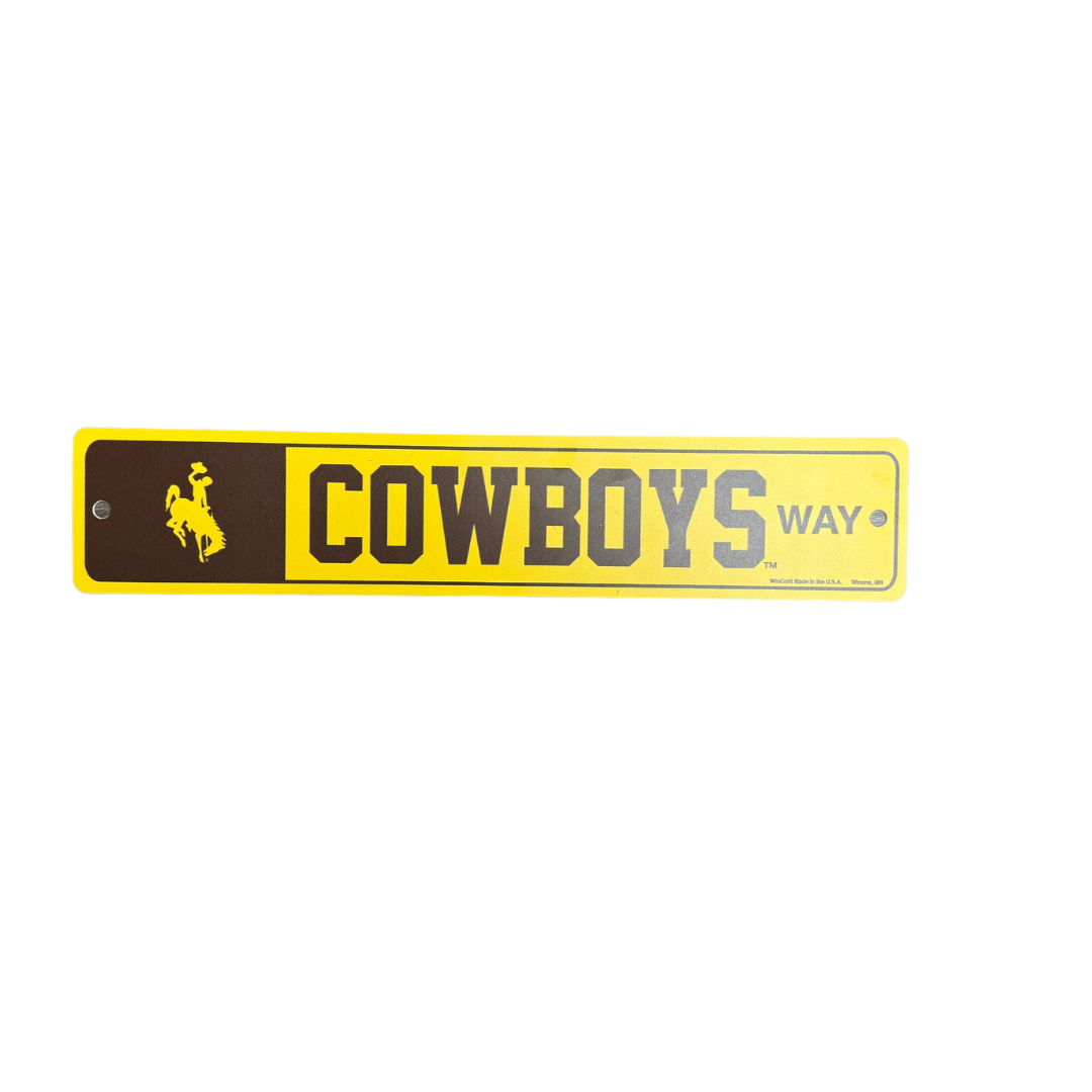 Brown and gold plastic street sign, design is brown box with gold bucking horse inside, brown word Cowboys