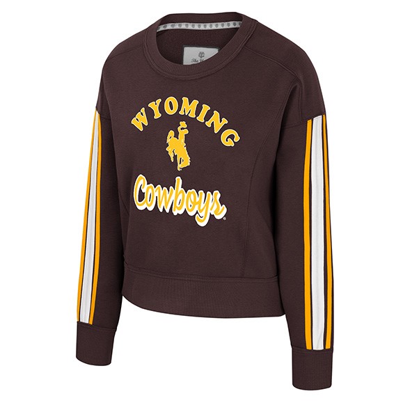 brown womens crewneck with design center chest. design is gold arched wyoming lettering with bucking horse below and scripted cowboys below that in gold. has gold and white horizontal stripes on both sleeves