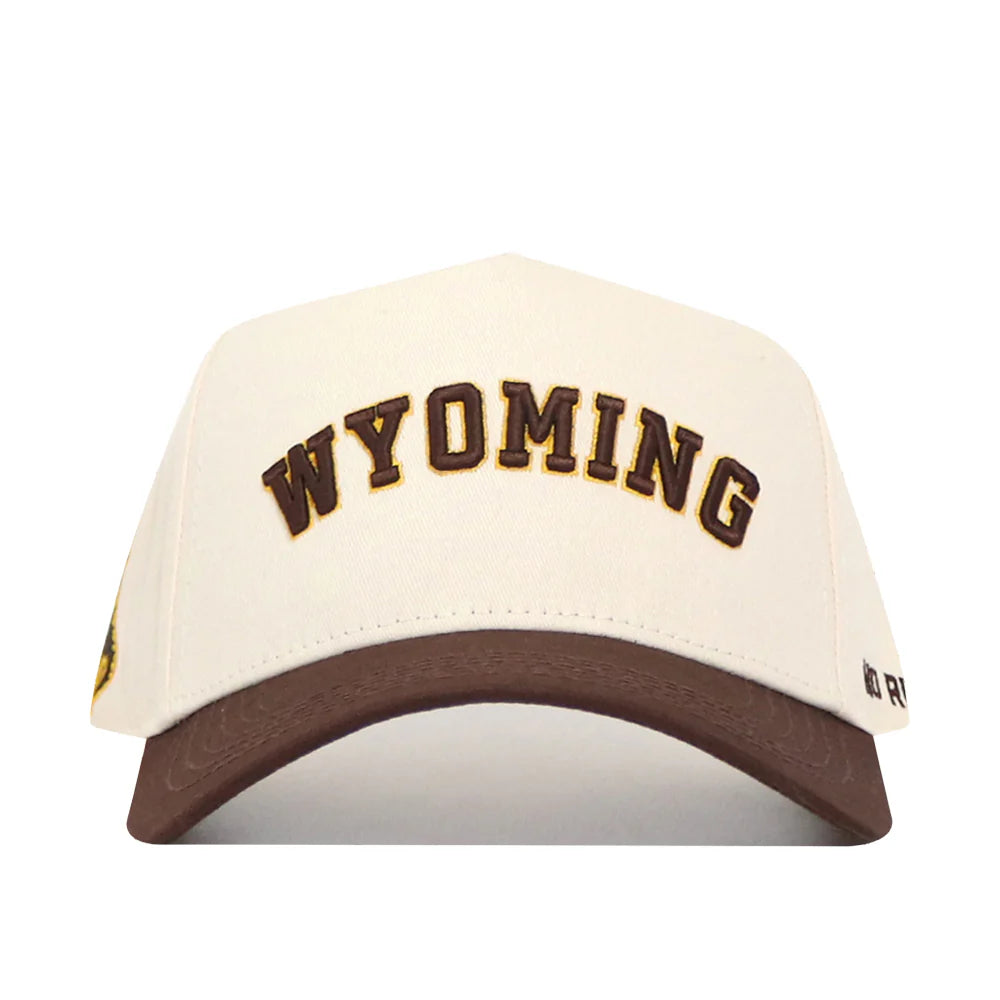 cream adjustable hat with brown bill. has brown wyoming letters embroidered on front panel with white outline