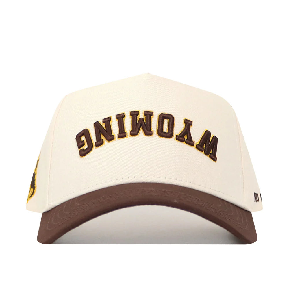 cream adjustable hat with brown bill. has brown upside down wyoming letters embroidered on front panel with white outline