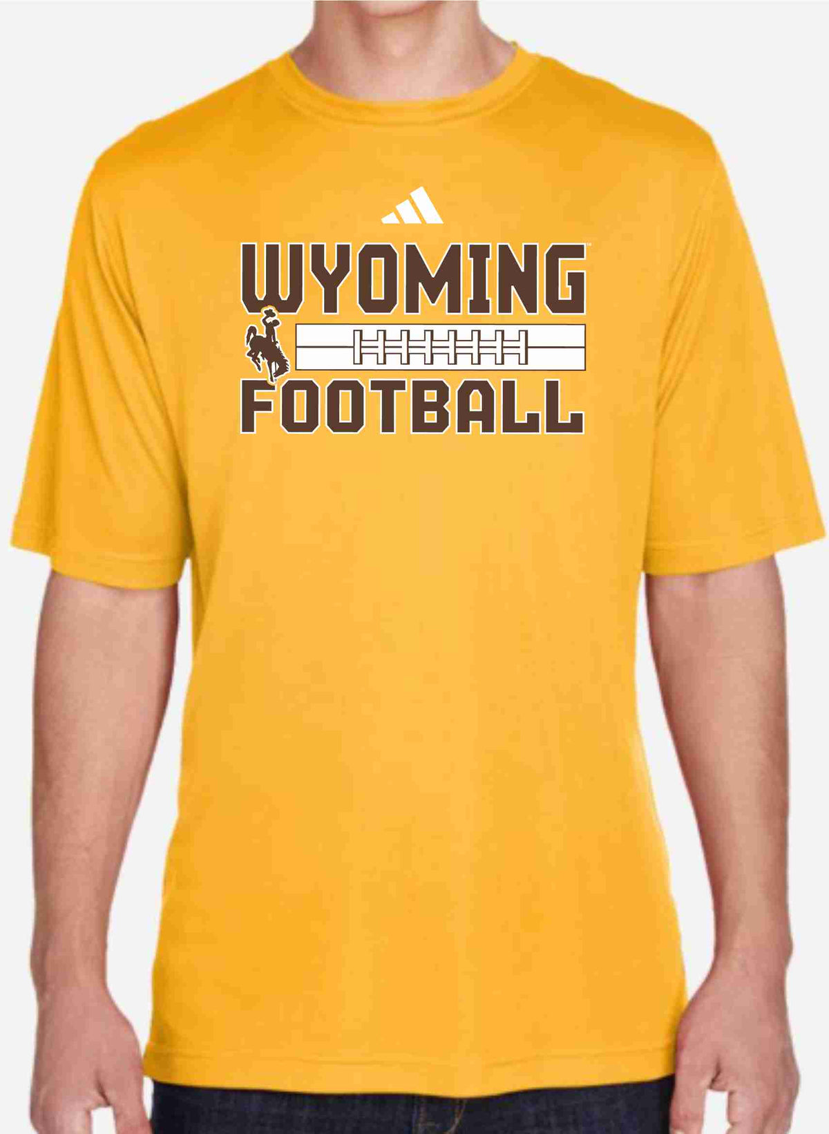 Model wearing a gold adidas tee shirt that has "wyoming football" and bucking horse logo on the front chest. Standing in front of a white background.
