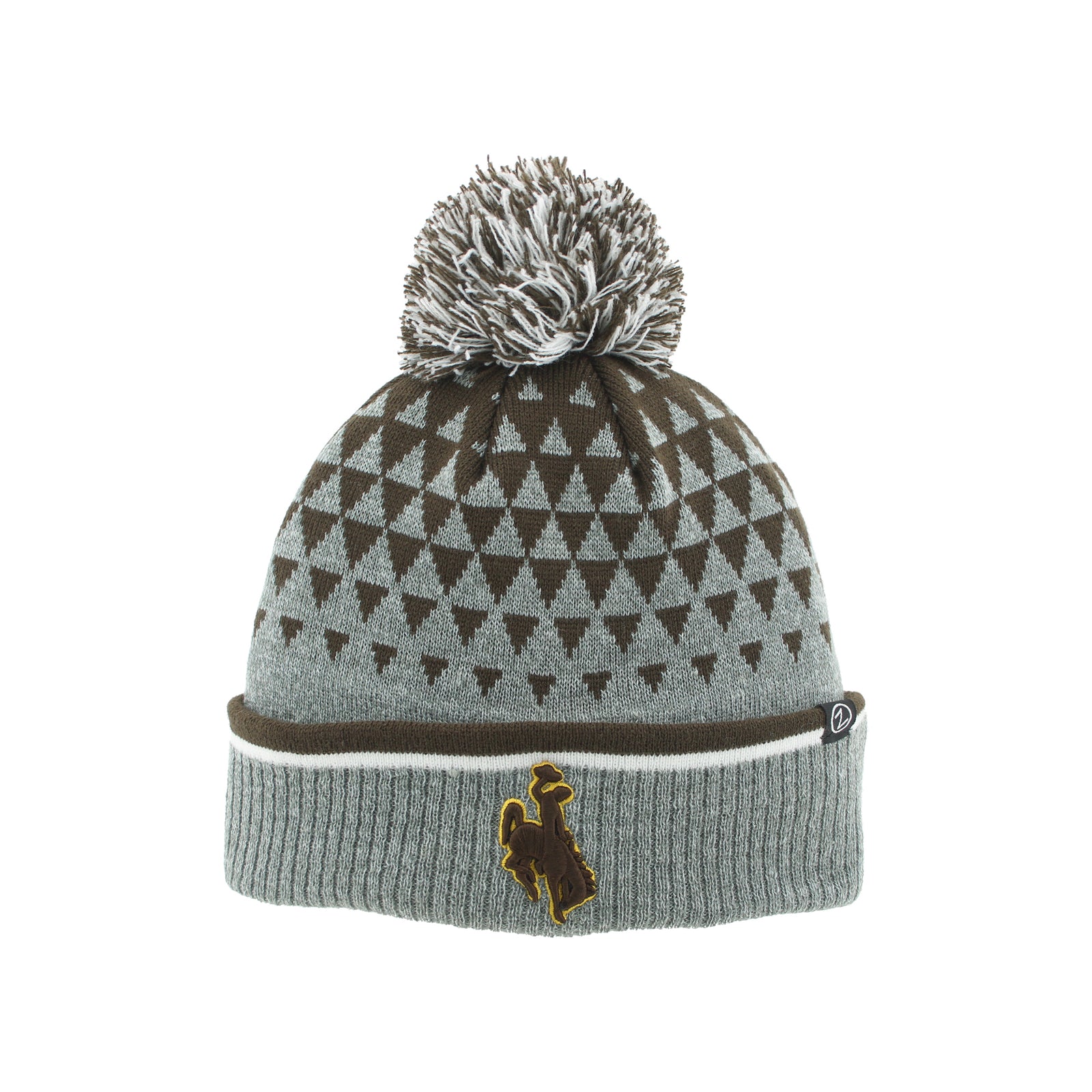 A gray and brown knit pom-pom beanie with a geometric triangle pattern on the crown, a ribbed cuff, and a small bucking horse logo on the front.
