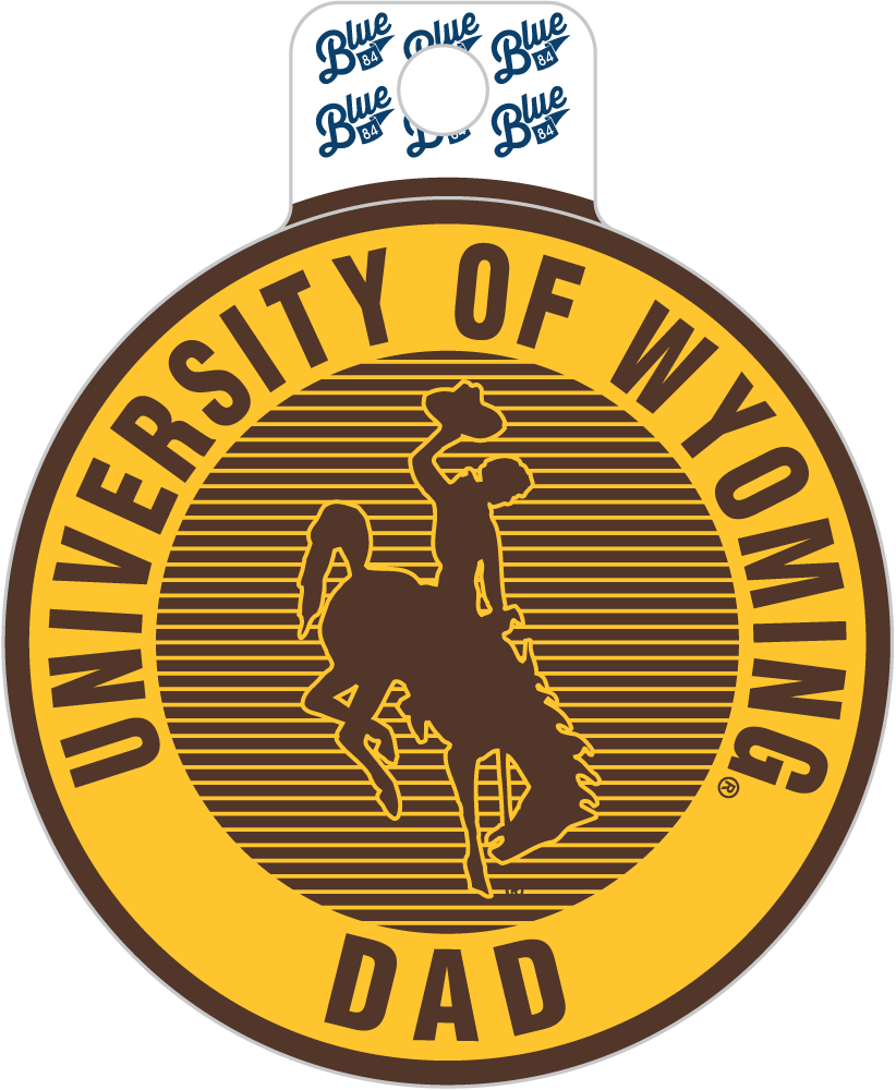 A die-cut sticker or decal featuring the University of Wyoming logo with a cowboy on a bucking horse. The design has a yellow outer ring with dark brown text reading 'UNIVERSITY OF WYOMING dad' and a dark brown striped center with the cowboy silhouette.