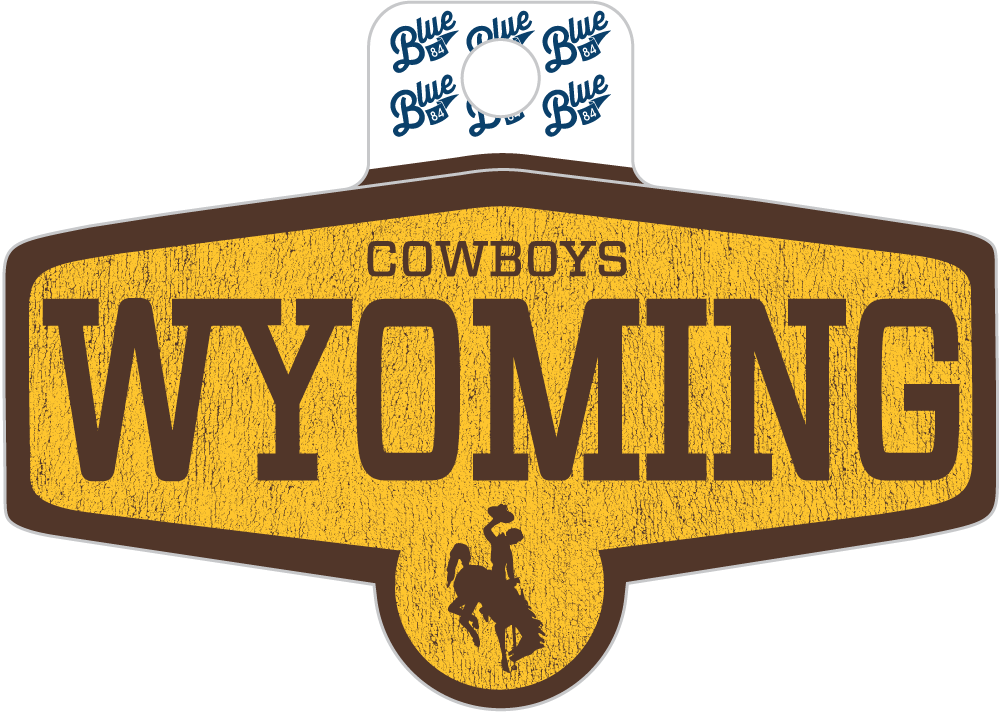 A Wyoming Cowboys decorative sign or magnet featuring a distressed yellow and brown shield design with the word 'WYOMING' and a cowboy silhouette, plus a small white hanging tab printed with the word 'Blue' repeated.