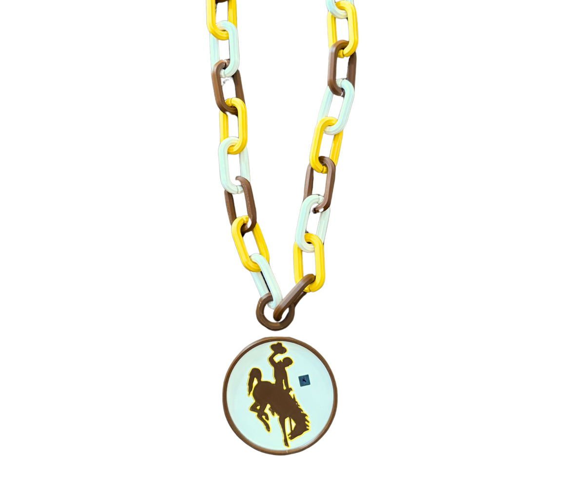 Brown and gold and white chain with round ornament hanging from it. Ornament has a brown bucking horse logo in the middle.  This hype chain is pictured on a white background.