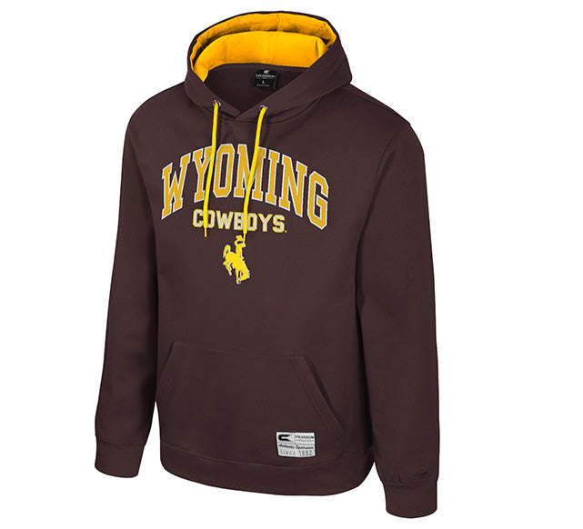 A dark brown pullover hoodie with a yellow interior hood lining and yellow drawstrings. The front features 'WYOMING COWBOYS' printed in yellow varsity lettering with a cowboy silhouette logo below it.
