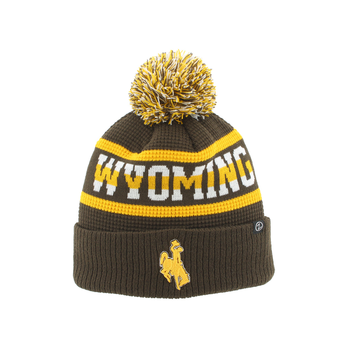 A dark brown knit beanie with a yellow and white pom-pom, featuring the word 'WYOMING' in white with a yellow outline across the middle, and a yellow bucking horse logo on the folded cuff.