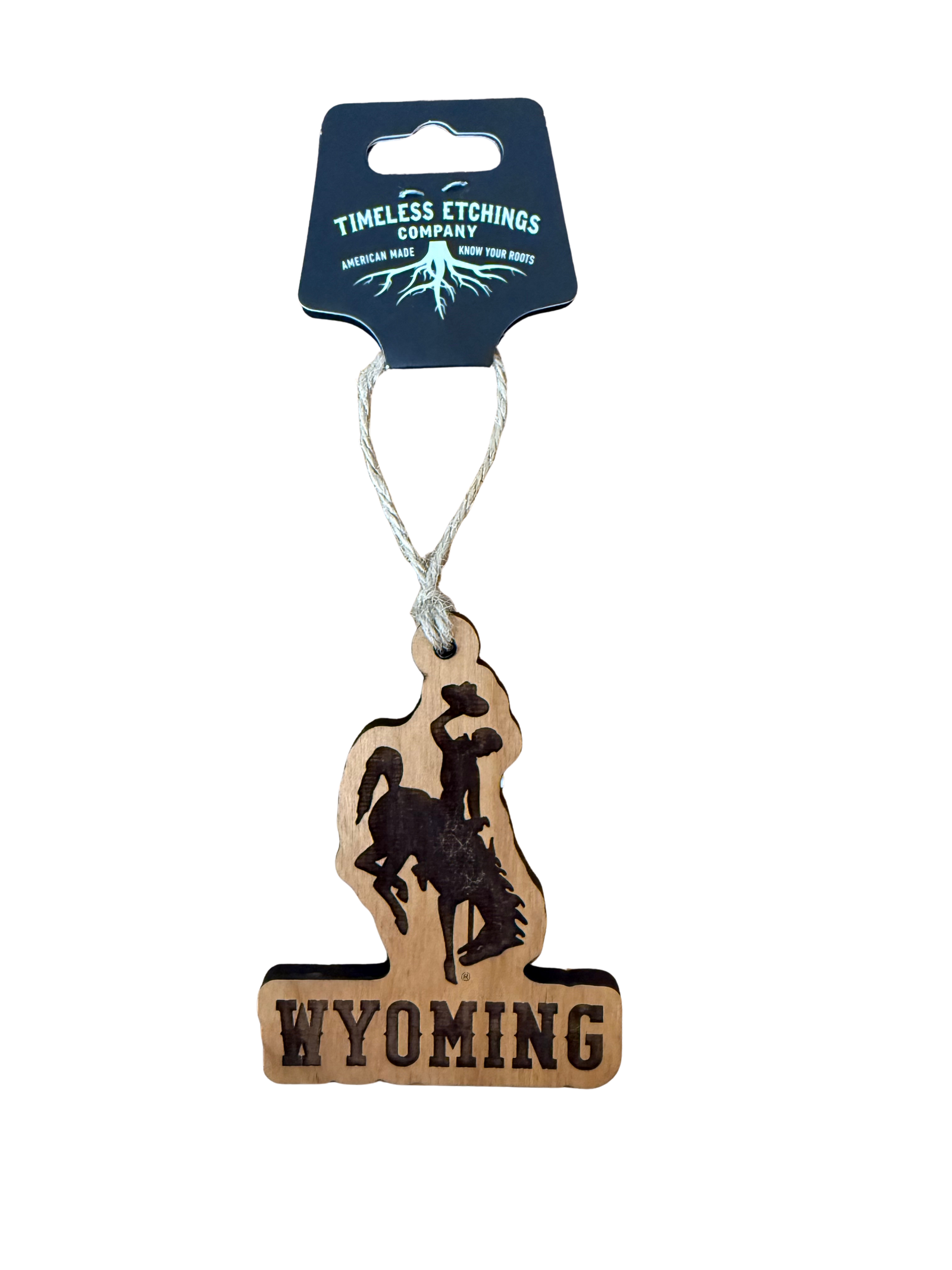 Wooden Ornament with 'Wyoming" and a bucking horse etched hanging from a timeless etching company tag
