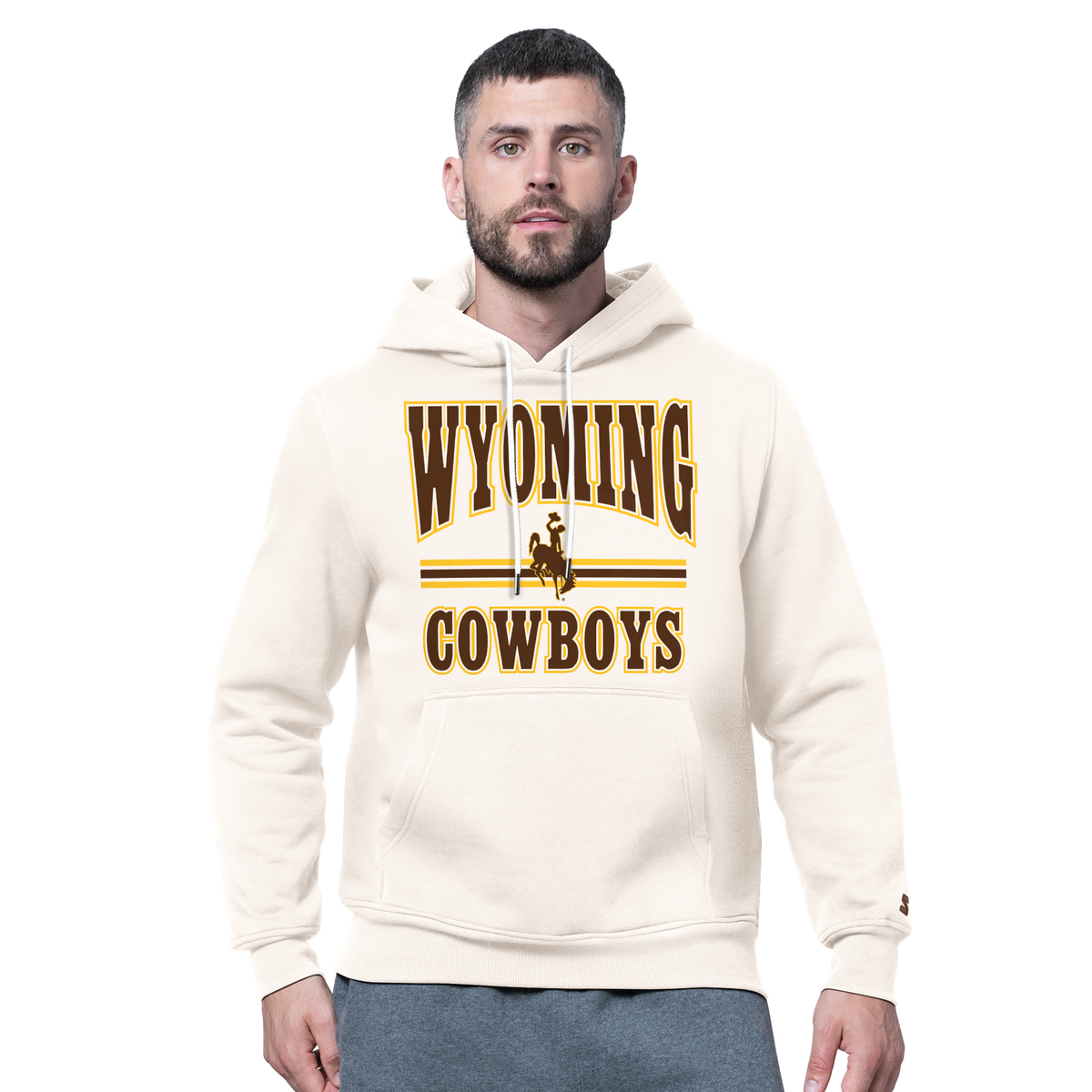 Man modeling a ivory sweatshirt with wyoming cowboys and bucking horse logo on front with kangaroo pocket. Pictured on a white background.