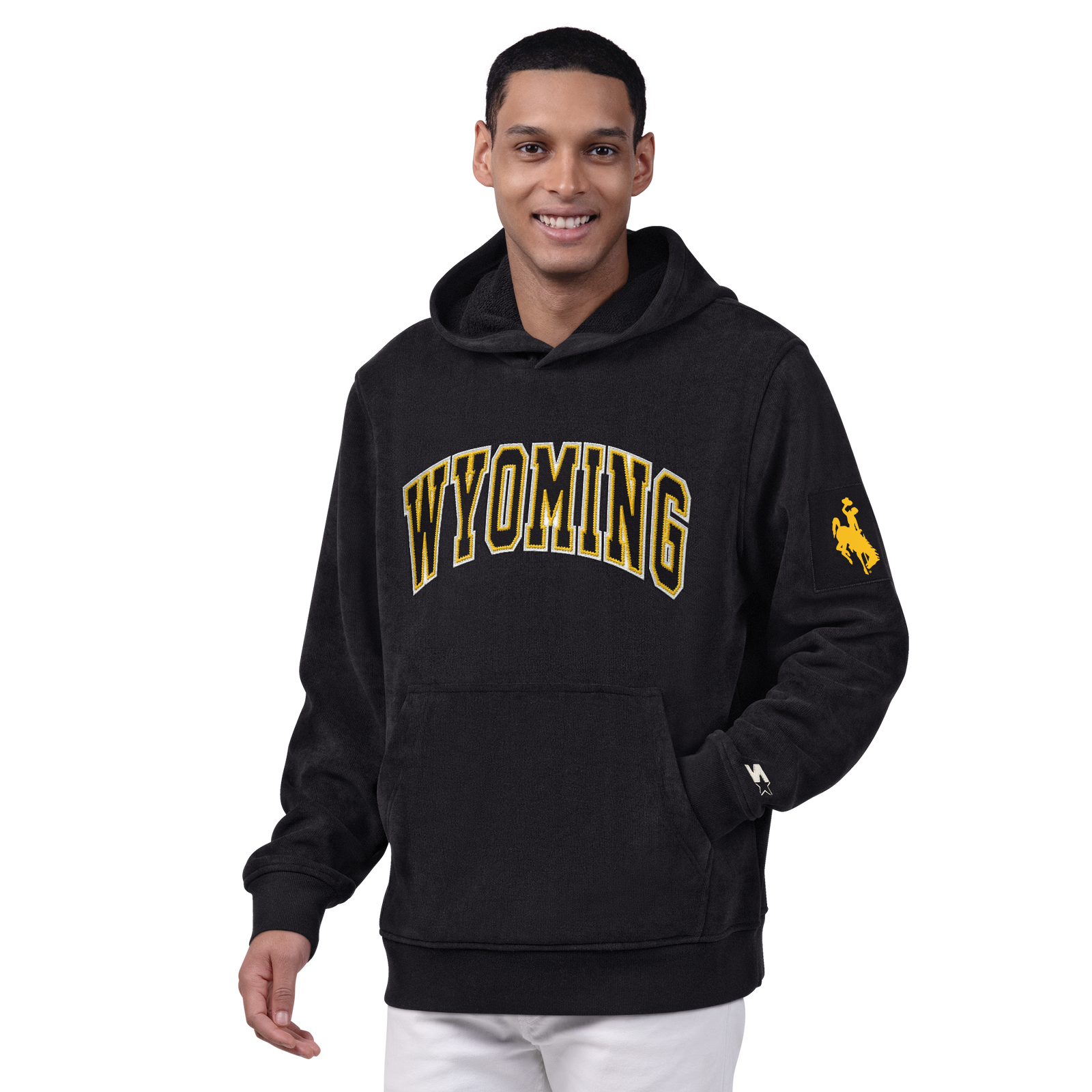 Man wearing black hooded sweatshirt with wyoming lettering on the front and gold bucking horse logo on the left sleeve. Pictured on a white background.