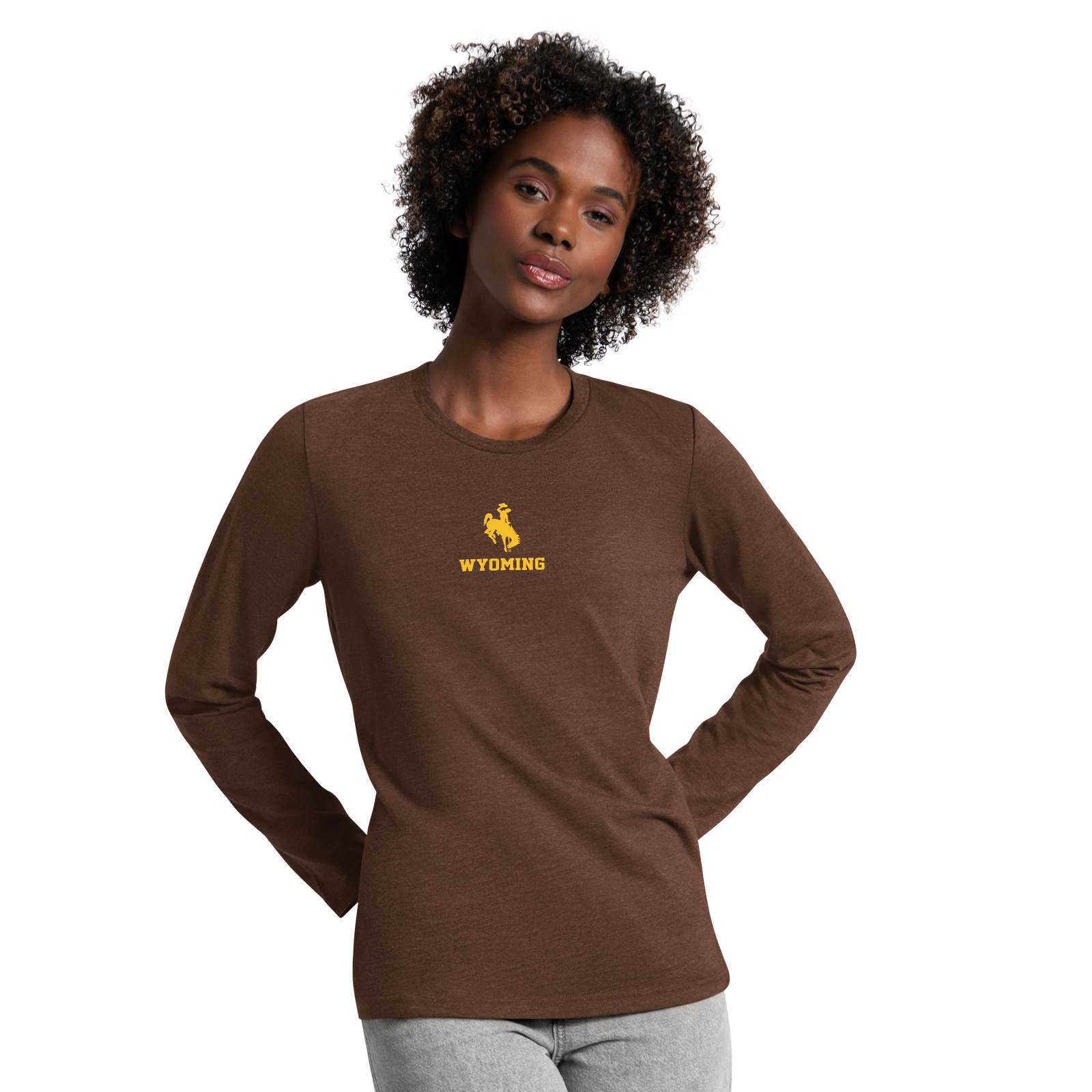 A woman modeling a brown long-sleeve t-shirt with a yellow 'Wyoming' cowboy logo on the chest, set against a plain white background.