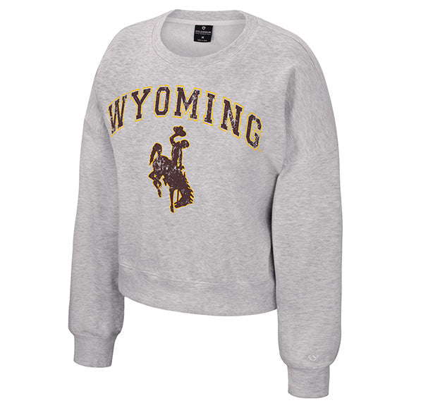 A light heather gray cropped sweatshirt featuring 'WYOMING' and bucking horse logo printed in brown and gold on the front, displayed against a plain white background.