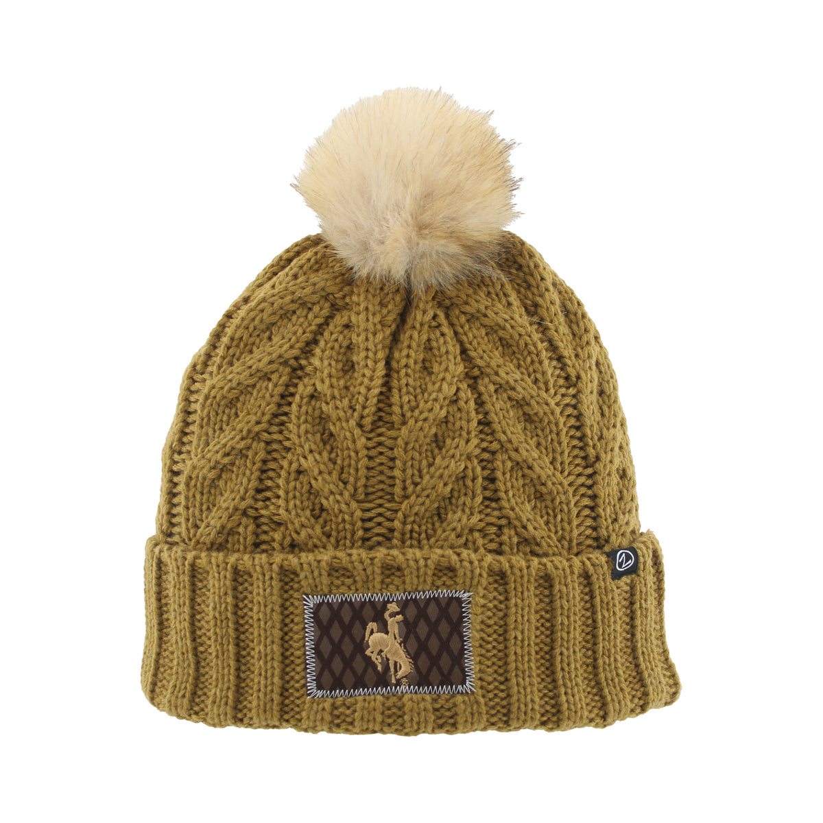 A cable-knit beanie hat in a warm olive-brown color, featuring a fluffy cream pom-pom on top and a brown embroidered patch on the folded cuff.
