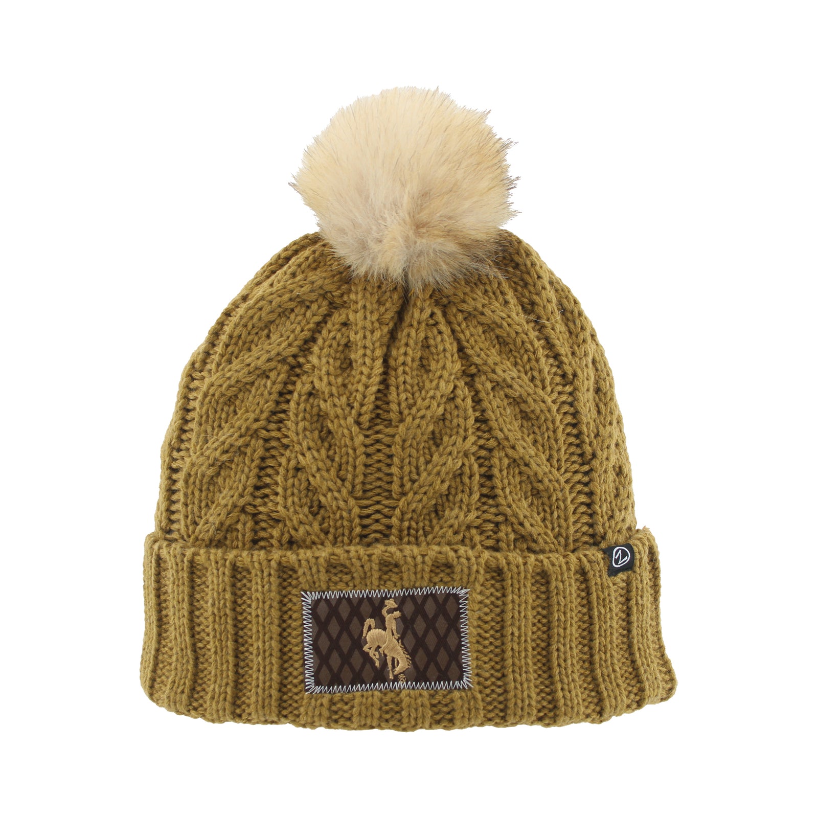 A cable-knit beanie hat in a warm olive-brown color, featuring a fluffy cream pom-pom on top and a brown embroidered patch on the folded cuff.