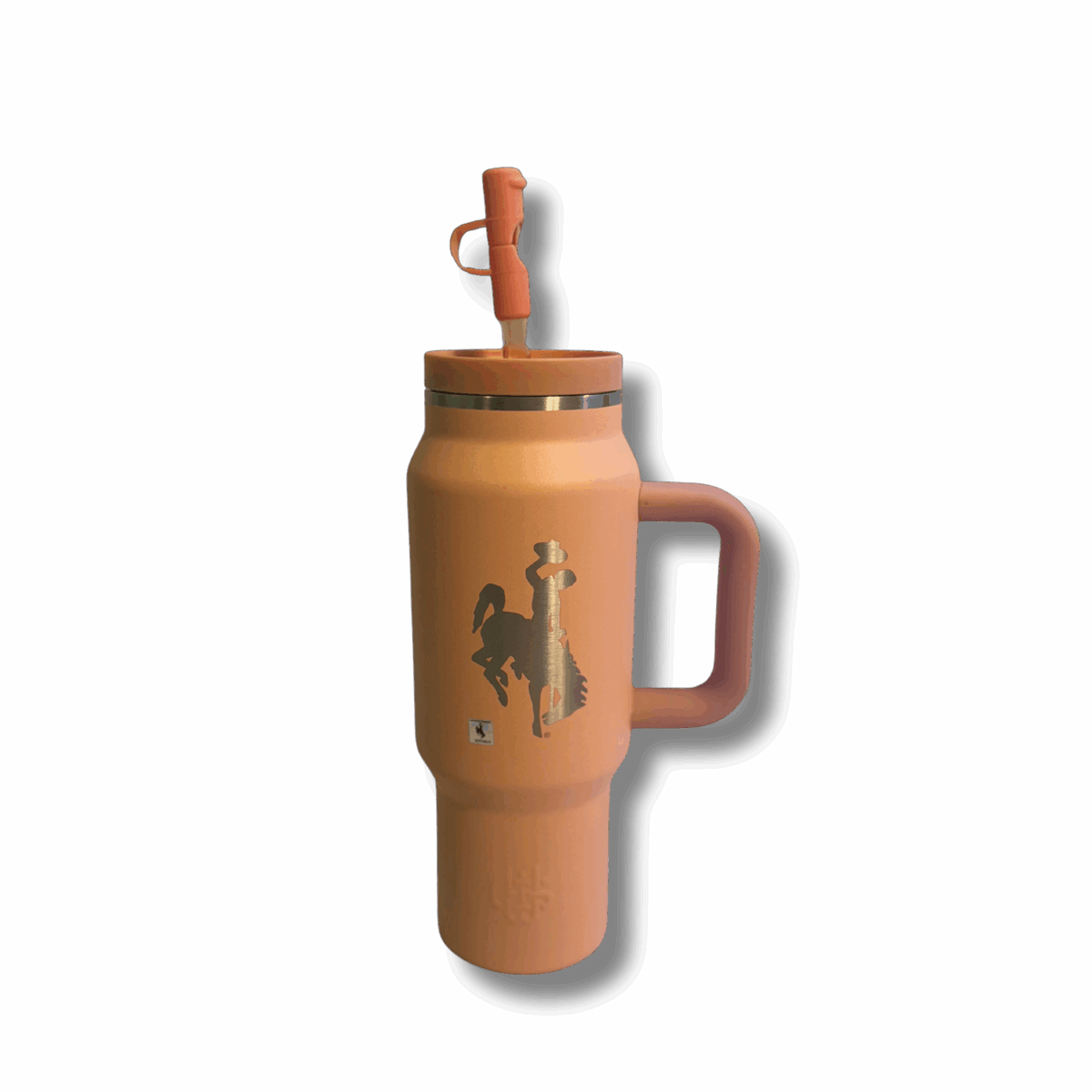 30oz travel tumbler. peach colored with straw lid. has etched bucking horse on one side