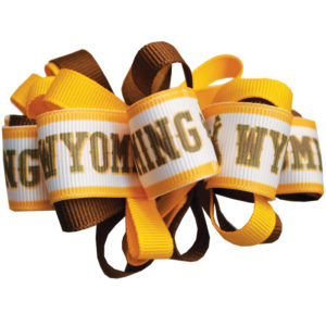 gold, brown and white looped hair bow, white ribbon has brown word Wyoming repeated in brown and gold on white ribbon