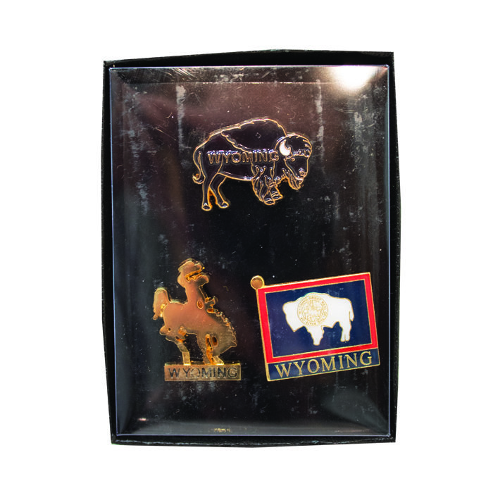 Brown buffalo shaped pin with word Wyoming, gold bucking horse shaped pin with word Wyoming in bar below, state flag pin with word Wyoming in blue bar below