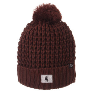 brown knit beanie with brown pom on top and folded over front. small grey patch with black bucking horse sewn on front
