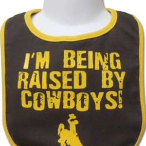 brown baby bib with gold seams, design is words I'm being raised by cowboys in distressed gold, gold bucking horse below