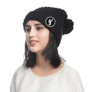 women's slouchy knit beanie with pom in black. black fabric patch with white bucking horse in the center, sewn onto the cuff of beanie