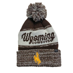 brown and white marled beanie. Slogan Wyoming Cowboys knitted in front of beanie. Gold bucking horse embroidered on front cuff. brown and white pom on top