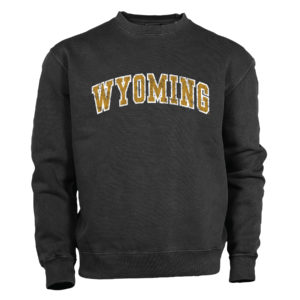garment washed charcoal crewneck sweatshirt with word Wyoming arced in the center of garment. Wyoming is distressed and printed in gold with white outline
