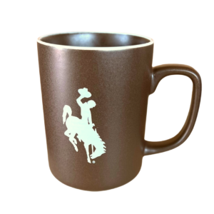 brown mug with white trim around rim, white bucking horse printed on front center