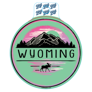 teal, circular decal with word Wyoming in black and mountain scene with moose in pink and black
