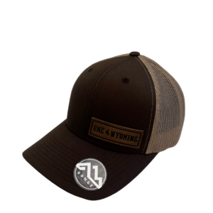 structured, mid profile adjustable hat. brown front, khaki mesh back. Leather rectangular patch on left side of hat with slogan One Wyoming