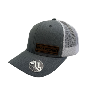 structured, mid profile adjustable hat. grey front, white mesh back. Leather rectangular patch on left side of hat with slogan One Wyoming