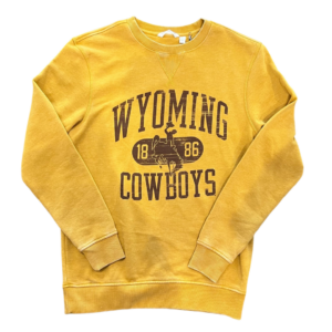 faded gold crew neck, fleece sweatshirt. Slogan Wyoming Cowboys, with bucking horse and 1886 in the middle printed in brown on front of sweatshirt