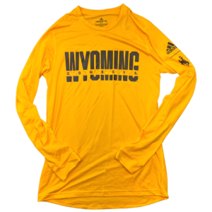 Adidas gold long sleeved tee. Word Wyoming in brown on front with cut out. inside cut out is word Cowboys printed smaller in brown. Bucking horse and Adidas logo printed on left sleeve