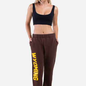 woman wearing brown short sweatpants, design is vertical word Wyoming in gold on right leg