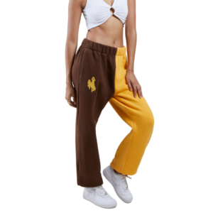 woman wearing sweatpants with elastic waistband. right leg is brown, and left leg is gold. gold bucking horse printed on top left side of pant.