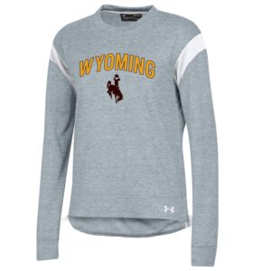 under armour grey women's long sleeve tee, white stripes at shoulders, design is word Wyoming in gold outlined in brown above brown bucking horse
