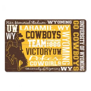wooden sign, design is varying Wyoming slogans in gold, brown and white varying fonts. Bucking horse logo on left corner