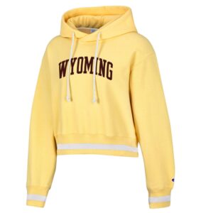 women's light yellow cropped hooded sweatshirt, design is word Wyoming in brown, waist band has white stripe in middle, embroidered champion logo on left sleeve