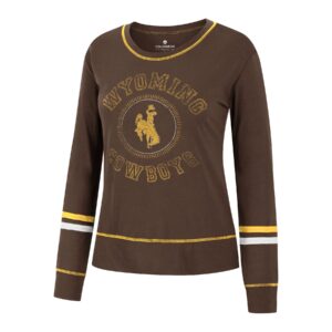 women's brown long sleeve tee, gold hem, gold and white stripes around arms, faded gold word Wyoming arched above circle with gold bucking horse in middle above faded gold word cowboy