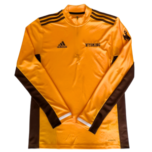 gold pull over jacket. Brown accent fabric on shoulders, side seams and bottom of sleeves. Brown Adidas logo embroidered on right chest, word Wyoming embroidered on left chest. Brown bucking horse on left sleeve