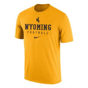Nike men's gold tee, design is brown bucking horse above brown word Wyoming, word Wyoming is above brown word football above brown Nike logo