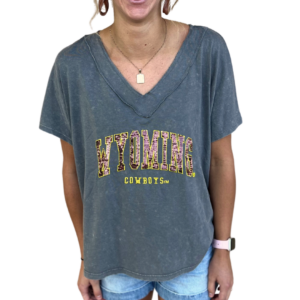 Grey women's v neck tee, design is brown word Wyoming gold outline above gold word cowboys