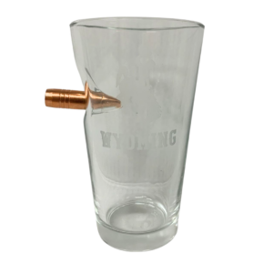 Pint glass with copper bullet detail, design is etched bucking horse above word Wyoming