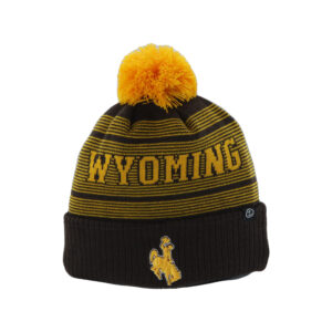 Brown beanie with gold stripes, design is gold word Wyoming above gold bucking horse, gold pom detail on top