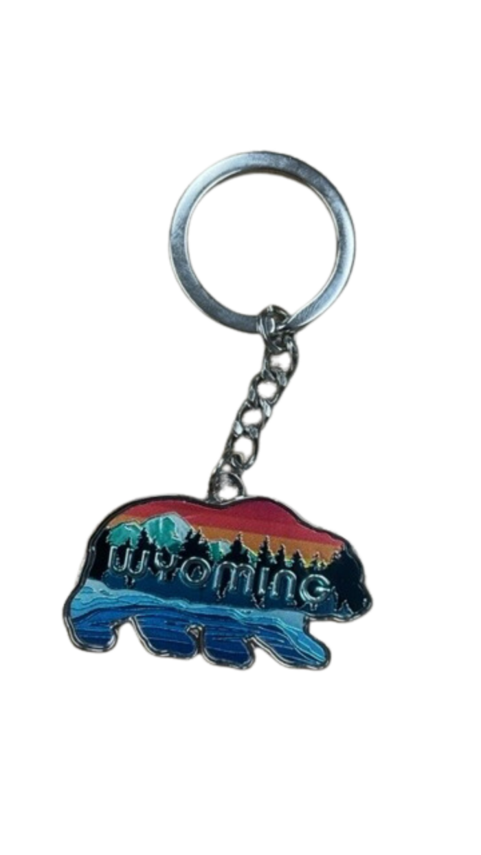 Bear shaped keychain, design is word Wyoming in front of nature scene