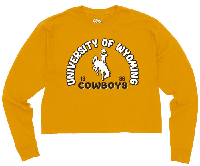 gold cropped long sleeve t-shirt with design on front. Design is university of wyoming in a half circle arc with cowboys under. UWYO in white with brown outline, Cowboys, brown, with white outline. White bucking horse in center of arc.