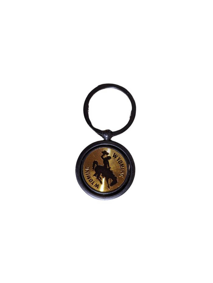 Metal keychain. on circular metal chain with a black outer edge and silver center. Wyoming engraved with bucking horse in center of chain.