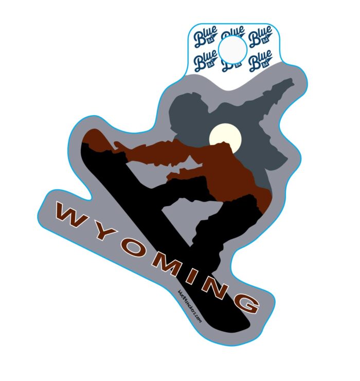 Snowboarder shaped decal, design is blue, brown, and black mountain range outlines with moon above brown word Wyoming